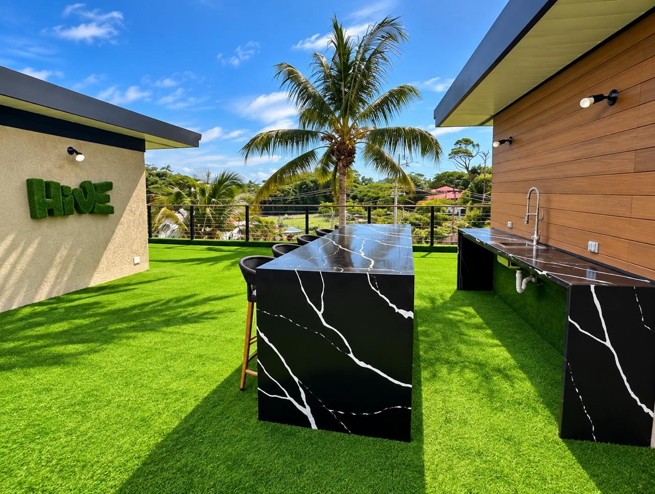 The Hive Crown Point rooftop lounge with black marble table and lawn